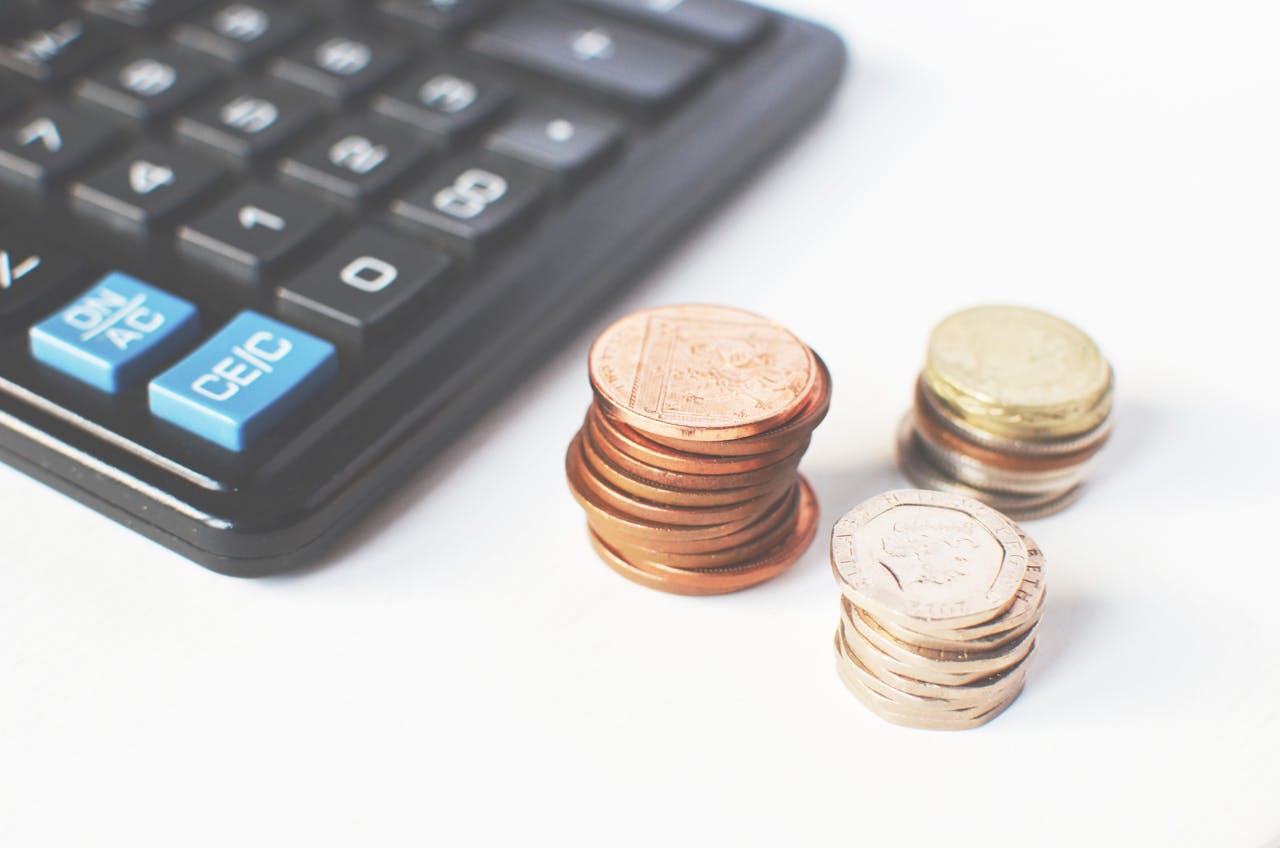 creative Close-up of stacked coins and a calculator symbolizing financial strategy and budgeting.